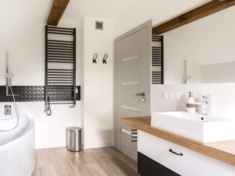 Modern spacious bathroom in black and white decor with a big bath